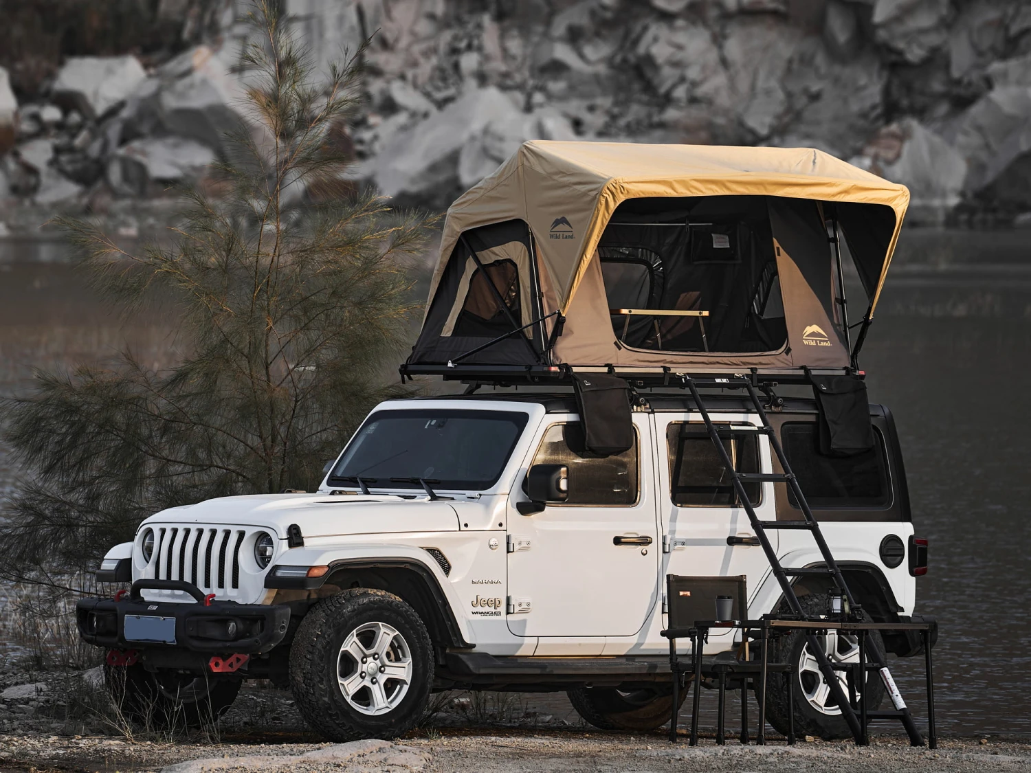 Otwarty namiot dachowy Wild Land Normandy Auto PRO 140 na dachu Jeepa, gotowy do użytku.